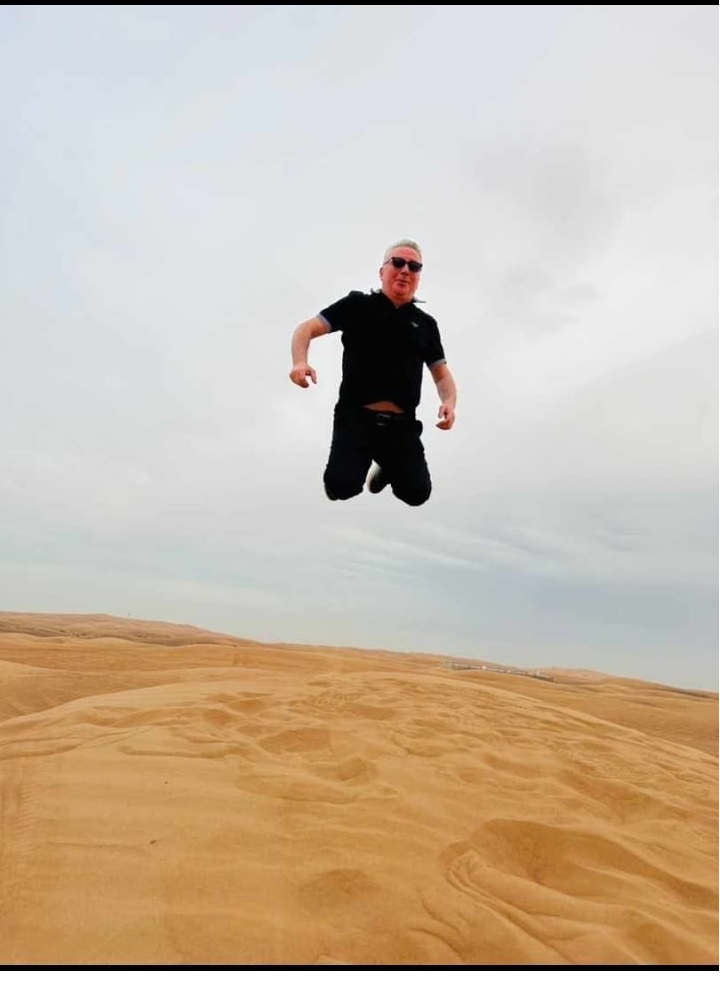 Man jumping in the desert during an adventure safari by Royal Viking Tourism.