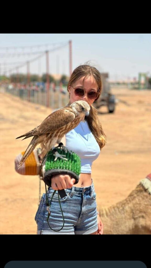 Woman holding a falcon during Dubai desert safari by Royal Viking Tourism.