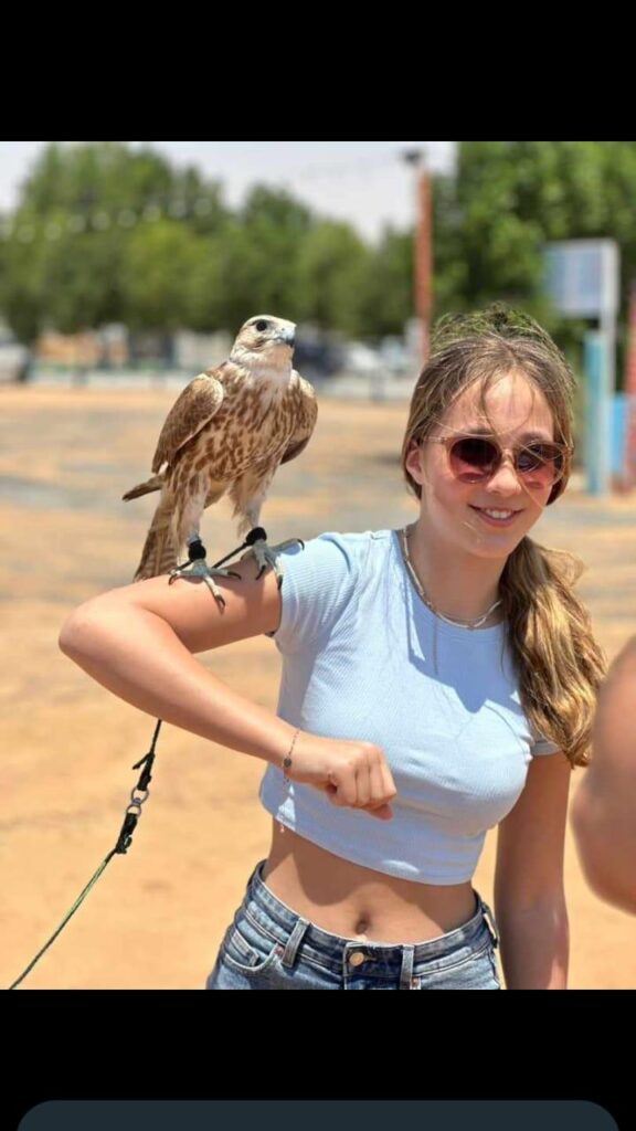 Woman holding a falcon on her arm during Dubai desert safari by Royal Viking Tourism.