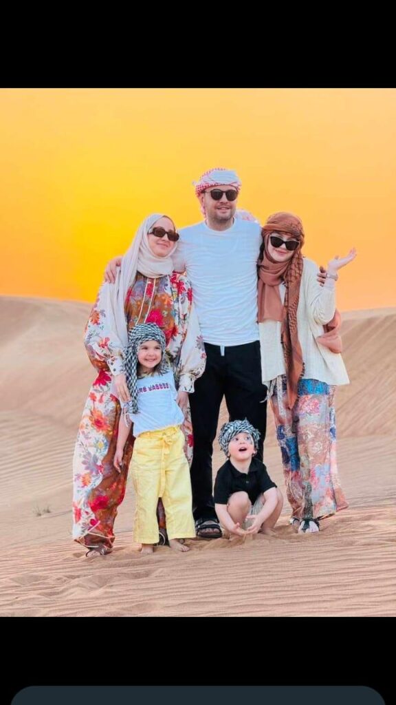 Family posing for a photo during Dubai desert safari by Royal Viking Tourism.