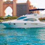 Luxurious yacht cruising in front of the iconic Atlantis Hotel, Dubai.