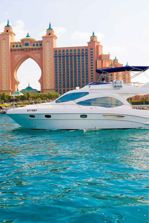 Luxurious yacht cruising in front of the iconic Atlantis Hotel, Dubai.